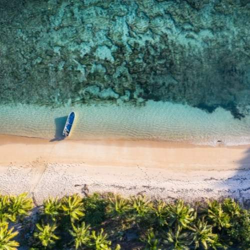 ariel-view-of-small-boat-docked-at-a-beach-in-fiji