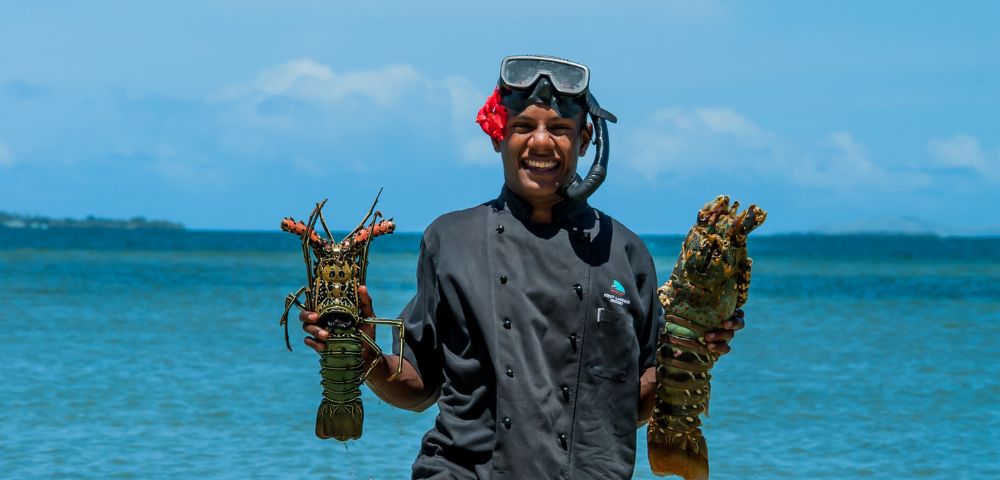 my-fiji-chef-holding-two-shellfish-fresh-from-the-water-at-first-landing-beach-resort-villas-in-lautoka