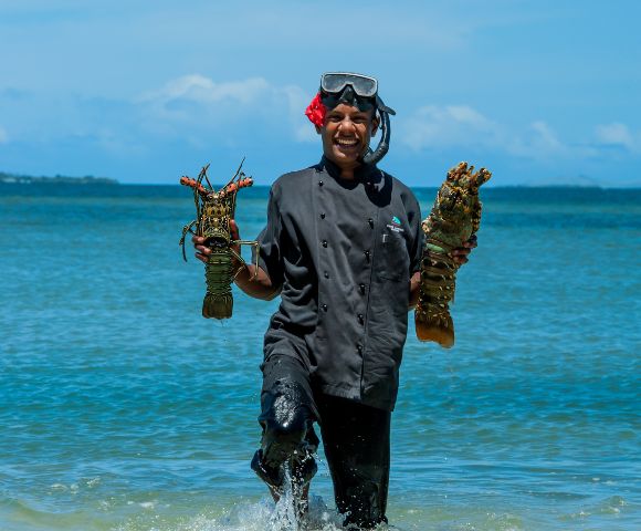 my-fiji-chef-holding-two-shellfish-fresh-from-the-water-at-first-landing-beach-resort-villas-in-lautoka