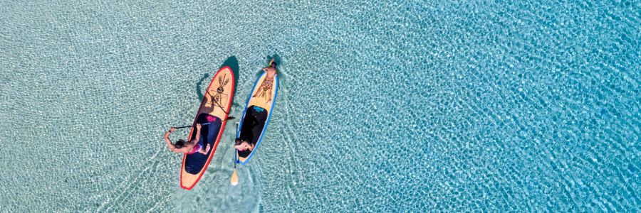 my-fjii-birds-eye-view-of-a-family-stand-up-paddleboarding-in-clear-water-in-fiji