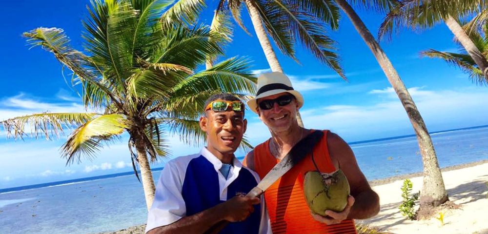 MY-HOLIDAY-Two-men-on-a-beach-undertaking-Coconut-Grating-at-Tambua-Sands-Beach-Resort