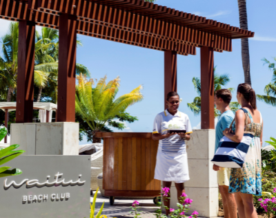 my-fiji-two-people-being-greeted-at-entry-to-waitui-beach-club-at-sofitel-fiji-resort-and-spa